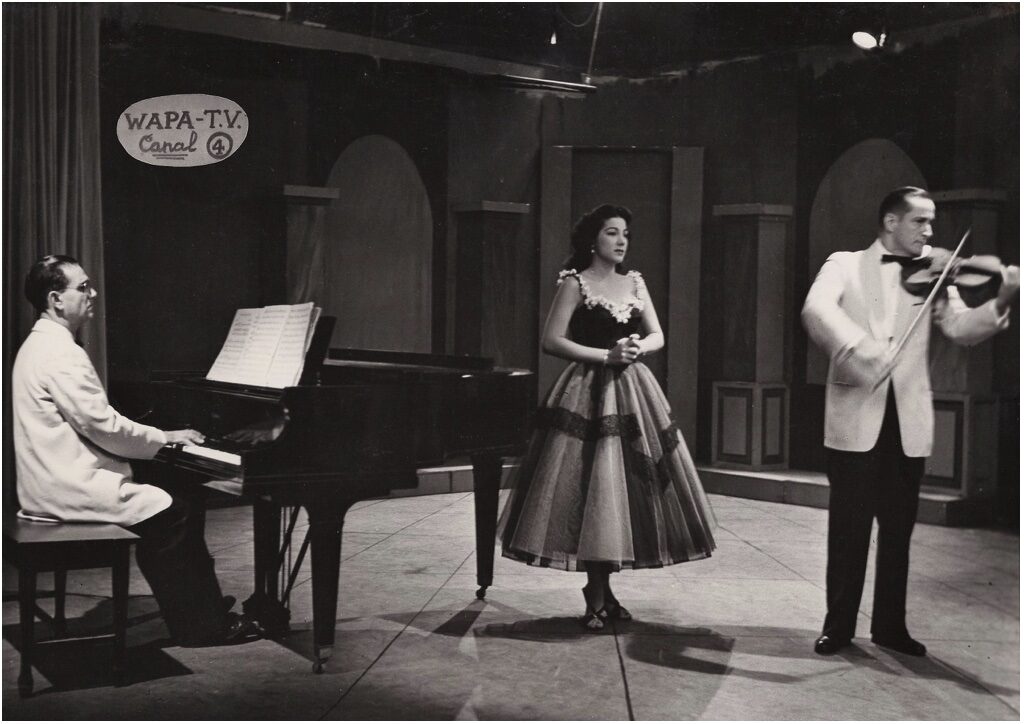 José Enrique Pedreira al piano y Henry Hutchinson, Sr. al violín mientras Olga Iglesias canta para la televisión WAPA a fines de la década de 1950.